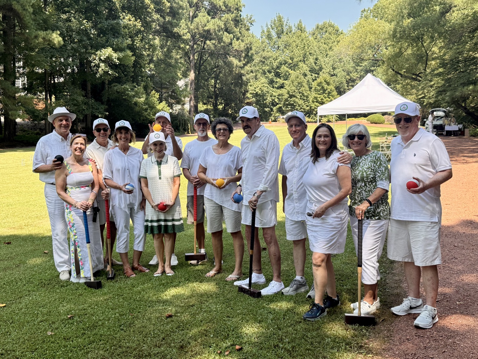 Guests in summer whites and club caps gathered on the lawn at Cross Creek